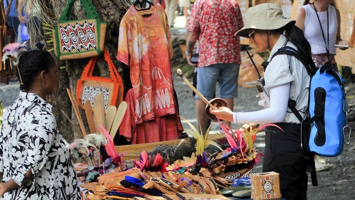 Warga menjelaskan lukisan dari kulit kayu kepada wisatawan mancanegara pada Festival Kulit Kayu Khombouw di Kampung Asei Besar, Distrik Sentani Timur, Kabupaten Jayapura, Papua, Kamis (10/10/2024). Festival yang pertamakali digelar tersebut bertujuan untuk mengeksplore potensi kerajinan suvenir dan lukisan dari kulit kayu. ANTARA FOTO/Gusti Tanati/YU