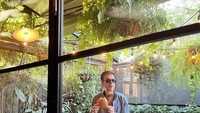 Ada juga keseruannya saat Manoj Punjabi mengunjungi restoran yang dipenuhi tanaman hijau di Australia. Dalam potret yang diambil candid, ia tampak memegang burger. Foto: Instagram @manojpunjabimd