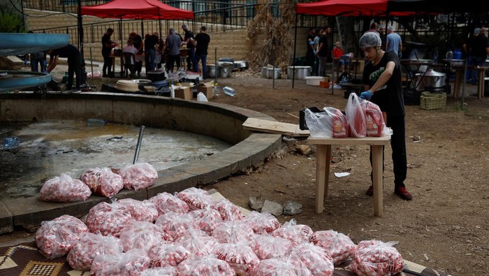 Potret Sibuknya Relawan Masak untuk Pengungsi Lebanon Volunteers prepare shawarma, a popular Lebanese dish, for the displaced people sheltered in schools, amid the ongoing hostilities between Hezbollah and Israeli forces in Beirut, Lebanon, October 10, 2024. REUTERS/Louisa Gouliamaki