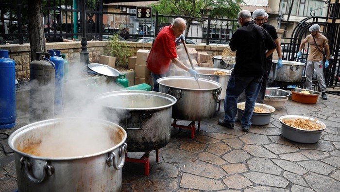 Potret Sibuknya Relawan Masak untuk Pengungsi Lebanon Volunteers prepare shawarma, a popular Lebanese dish, for the displaced people sheltered in schools, amid the ongoing hostilities between Hezbollah and Israeli forces in Beirut, Lebanon, October 10, 2024. REUTERS/Louisa Gouliamaki