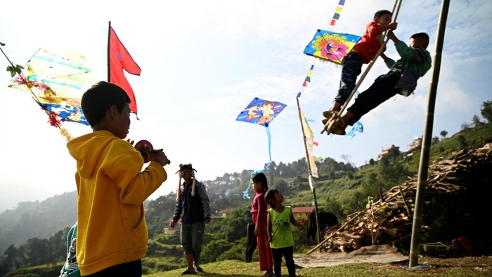 Anak-anak hingga remaja bermain ayunan yang terbuat dari bambu di Kathmandu, Nepal. Kegiatan itu merupakan salah satu dari perayaan festival Dashain.