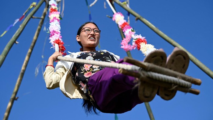Anak-anak hingga remaja bermain ayunan yang terbuat dari bambu di Kathmandu, Nepal. Kegiatan itu merupakan salah satu dari perayaan festival Dashain.