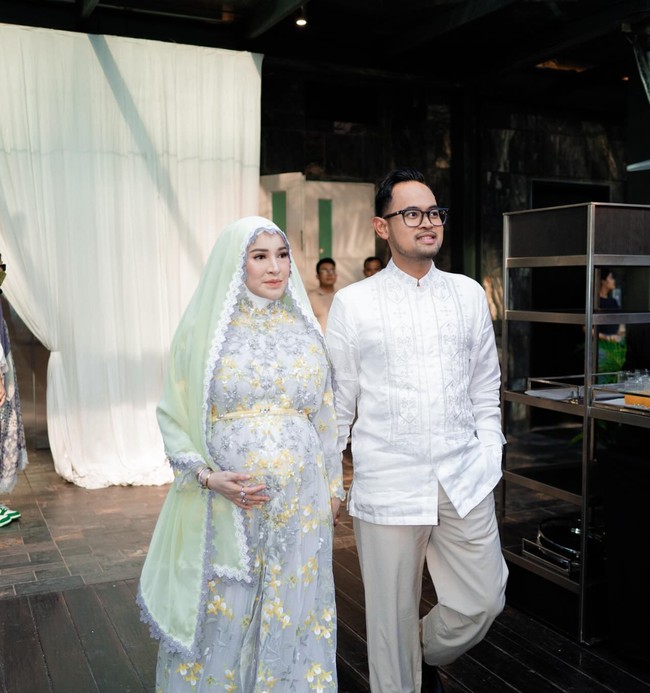 Di awal acara Shandy dan Juragan 99 terlihat kompak mengenakan busana dengan warna earth tone. Shandy mengenakan dress panjang abu-abu dengan motif bunga berwarna kuning. Ia kemudian melengkapi penampilannya dengan kerudung berwarna hijau muda. Foto: Instagram/@shandypurnamasari