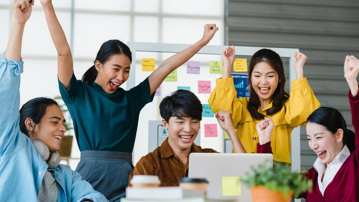 Group of Asia young creative people in smart casual wear discussing business celebrate giving five after dealing feeling happy and signing contract or agreement in office. Coworker teamwork concept.