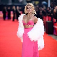 Penyanyi 25 tahun itu memadukan bralette dan rok panjang serta sarung tangan panjang yang semuanya hadir dalam warna pink fuchsia. Dia juga menambahkan mantel bulu putih saat berpose di karpet merah.Foto: Gareth Cattermole/Getty Images for BFI