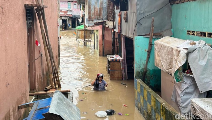 Warga saat melewati banjir di Kampung Aur Medan. (Foto: Kartika Sari/detikSumut).