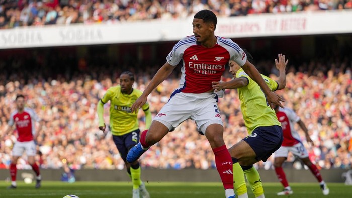 Arsenals William Saliba is challenged by Southamptons Yukinari Sugawara, right, during the English Premier League soccer match between Arsenal and Southampton at the Emirates Stadium in London, Saturday, Oct. 5, 2024. (AP Photo/Kirsty Wigglesworth)