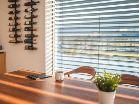 Digital tablet and white coffee cup on a wooden table in a modern apartment.