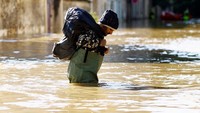 Warga berusaha menyelamatkan barang-barangnya dari banjir.