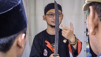 Sekjen Pelestari Golok Pedang Sepuh Joko Suseno menunjukkan salah satu golok yang dipamerkan kepada pengunjung saat Festival Golok Cakung di kawasan Kanal Banjir Timur, Jakarta, Sabtu (12/10/2024).