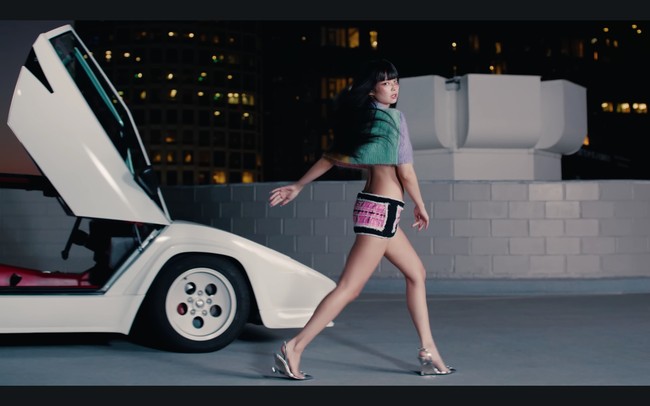 Dalam adegan lain, Jennie tampil dengan rambut hitam dan poni rata. Gayanya tak kalah seksi dengan bra hitam di balik atasan crop top Dsquared2 seharga Rp 8 jutaan dan mini skirt serasi dari brand lokal Korea itu. Foto: dok. YouTube JENNIE