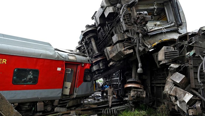 Police and railway officials work next to damaged coaches after a passenger train collided with a stationary goods train at the Kavaraipettai railway station in the southern state of Tamil Nadu, India, October 12, 2024. REUTERS/Riya Mariyam R