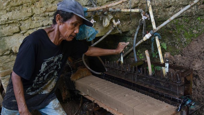 Produksi batu bata tradisional menurun Perajin menutup batu bata yang dijemur menggunakan terpal di Pakam, Deli Serdang, Sumatera Utara, Sabtu (12/10/2024). Tingginya curah hujan di daerah tersebut berdampak pada merosotnya produksi batu bata, jika musim kemarau perajin mampu memproduksi hingga 15.000 batu bata sedangkan pada musim penghujan hanya 5.000 ribu bata, dengan harga jual Rp300 per batu bata. ANTARA FOTO/Fransisco Carolio/Spt.
