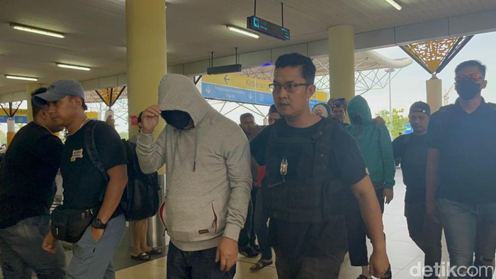 Tikui saat digiring pihak kepolisian di Bandara Jambi untuk diperika di Mabes Polri