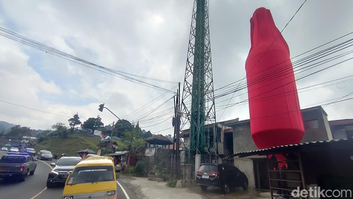 Tugu botol kecap masih terbungkus kain merah