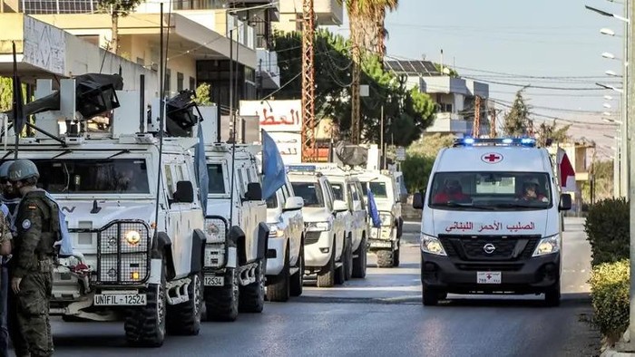 A Lebanese Red Cross ambulance moves past armored vehicles of the United Nations Interim Force in Lebanon (UNIFIL) during their patrol around Marjayoun in south Lebanon on October 8, 2024. (AFP)