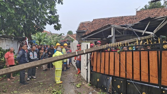 Angin kencang bikin tiang listrik tumbang timpa rumah warga di Bogor (Sholihin/detikcom)