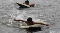 Sejumlah anak bermain air di kawasan Muara Baru, Penjaringan, Jakarta Utara, Minggu (13/10/2024) siang.