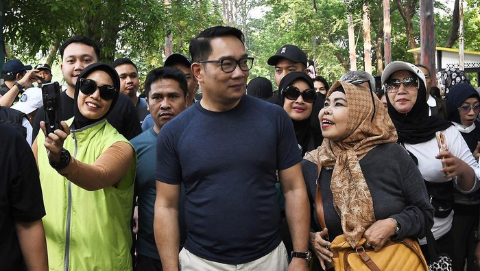 Calon Gubernur Jakarta Ridwan Kamil (tengah) memilih lauk untuk makan usai berolahraga di KBT (Kanal Banjir Timur) Duren Sawit, Jakarta Timur, Minggu (13/10/2024). Pada kegiatan tersebut Ridwan Kamil menyerap aspirasi warga dan berolahraga di KBT. ANTARA FOTO/ Fakhri Hermansyah/foc.