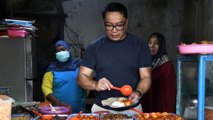 Calon Gubernur Jakarta Ridwan Kamil (tengah) memilih lauk untuk makan usai berolahraga di KBT (Kanal Banjir Timur) Duren Sawit, Jakarta Timur, Minggu (13/10/2024). Pada kegiatan tersebut Ridwan Kamil menyerap aspirasi warga dan berolahraga di KBT. ANTARA FOTO/ Fakhri Hermansyah/foc.