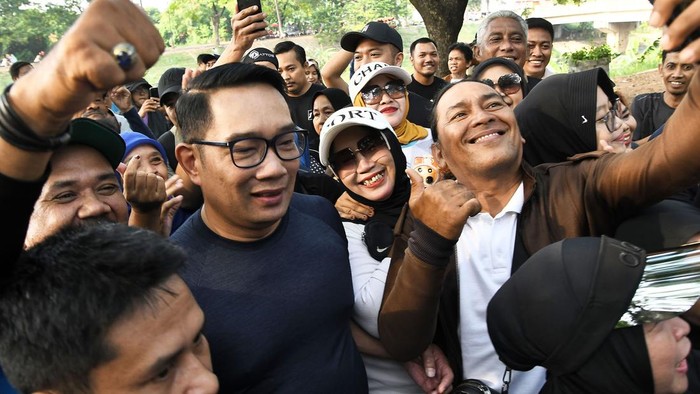 Calon Gubernur Jakarta Ridwan Kamil (tengah) memilih lauk untuk makan usai berolahraga di KBT (Kanal Banjir Timur) Duren Sawit, Jakarta Timur, Minggu (13/10/2024). Pada kegiatan tersebut Ridwan Kamil menyerap aspirasi warga dan berolahraga di KBT. ANTARA FOTO/ Fakhri Hermansyah/foc.