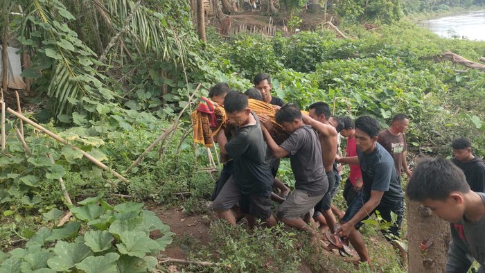 Warga saat mengevakuasi jasad lansia yang tenggelam di Sungai Musi