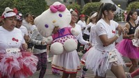 Perawat berusia 36 tahun Itzel Ramos menggendong boneka Hello Kitty berukuran besar selama lari sejauh 5K.  