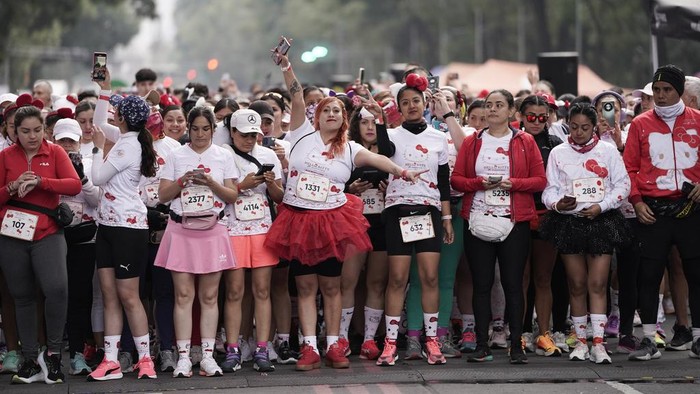 Fans of Japanese character Hello Kitty get ready for a race, during a celebration of the character's 50th anniversary, in Mexico City, Sunday, Oct. 13, 2024. (AP Photo/Aurea Del Rosario)