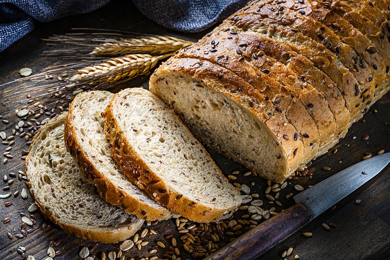 Healthy food: wholegrain and seeds sliced bread shot on rustic wooden table. Predominant color is brown. High resolution 42Mp studio digital capture taken with Sony A7rII and Sony FE 90mm f2.8 macro G OSS lens