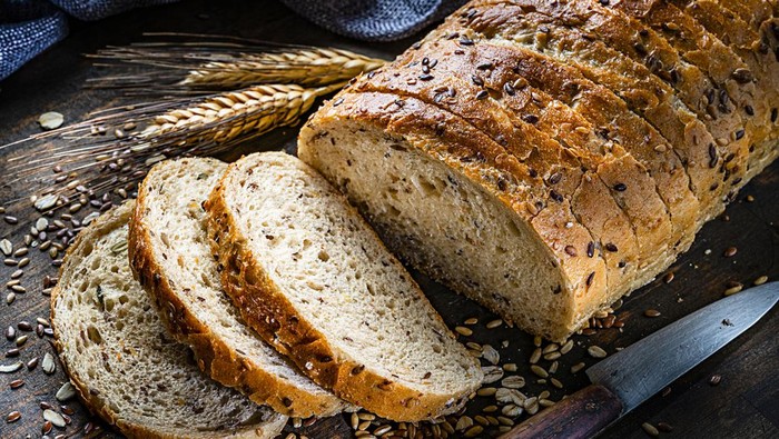Healthy food: wholegrain and seeds sliced bread shot on rustic wooden table. Predominant color is brown. High resolution 42Mp studio digital capture taken with Sony A7rII and Sony FE 90mm f2.8 macro G OSS lens