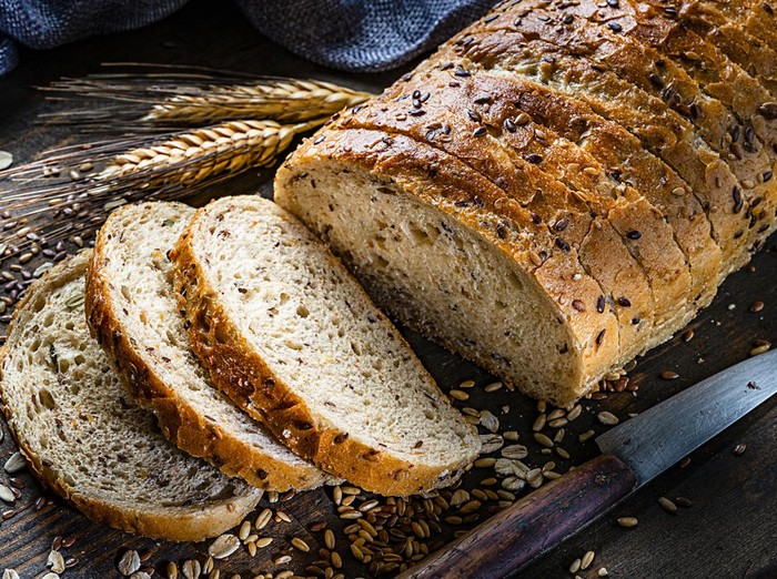 Healthy food: wholegrain and seeds sliced bread shot on rustic wooden table. Predominant color is brown. High resolution 42Mp studio digital capture taken with Sony A7rII and Sony FE 90mm f2.8 macro G OSS lens