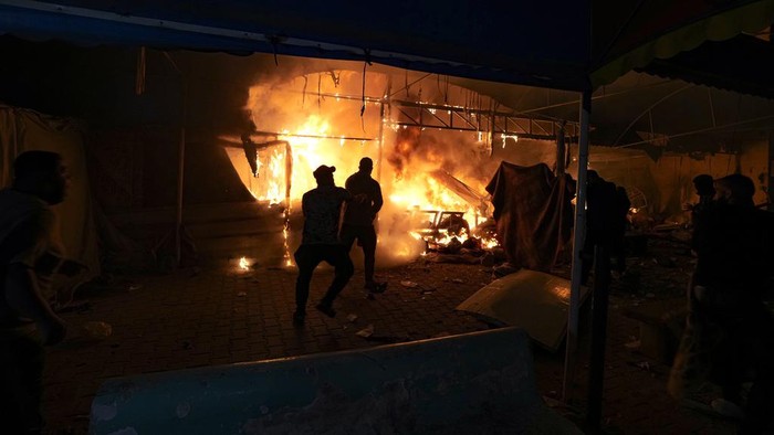 Palestinians react to a fire after an Israeli strike hit a tent area in the courtyard of Al Aqsa Martyrs hospital in Deir al Balah, Gaza Strip, Monday, Oct. 14, 2024. (AP Photo/Abdel Kareem Hana)