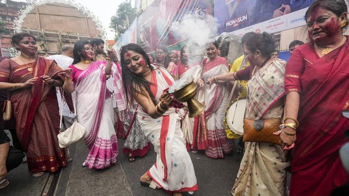 Festival Durga Puja, salah satu festival tahunan umat Hindu untuk memuja Dewi Durga. Dalam festival ini, wanita Hindu diberi polesan warna merah di wajahnya.