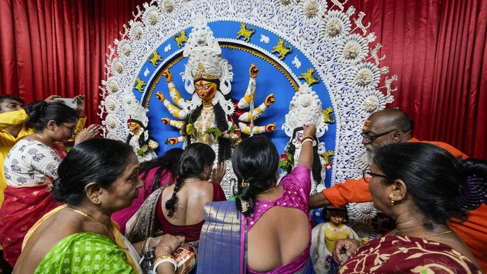 Festival Durga Puja, salah satu festival tahunan umat Hindu untuk memuja Dewi Durga. Dalam festival ini, wanita Hindu diberi polesan warna merah di wajahnya.