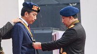 Presiden Joko Widodo (kiri) menerima anugerah medali kehormatan keamanan dan keselamatan publik Loka Praja Samrakshana dari Kapolri Jenderal Polisi Listyo Sigit Prabowo (kanan) di Mako Brimob, Kelapa Dua, Depok, Jawa Barat, Senin (14/10/2024).   
