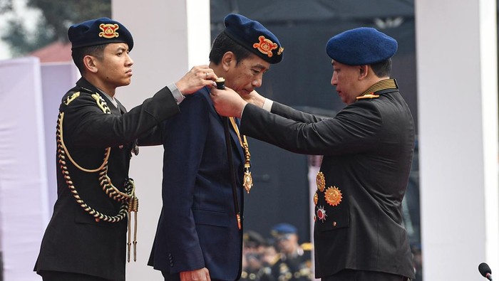 Momen Jokowi Dianugerahi Medali Kehormatan Loka Praja Samrakshana Polri Presiden Joko Widodo (tengah) menerima anugerah medali kehormatan keamanan dan keselamatan publik Loka Praja Samrakshana dari Kapolri Jenderal Polisi Listyo Sigit Prabowo (kanan) di Mako Brimob, Kelapa Dua, Depok, Jawa Barat, Senin (14/10/2024). Medali kehormatan keamanan dan keselamatan publik Loka Praja Samrakshana tersebut diberikan kepada Presiden Joko Widodo sebagai bentuk apresiasi Polri atas perannya dalam pengembangan organisasi Korps Bhayangkara. ANTARA FOTO/Muhammad Adimaja/rwa.