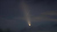 A satellite leaves a trail of light across the tail of the comet C/2023 A3 (Tsuchinshan-ATLAS), with an 80,000 year orbit, known as the comet of the century, after sunset in Ronda, Spain, October 13, 2024. REUTERS/Jon Nazca