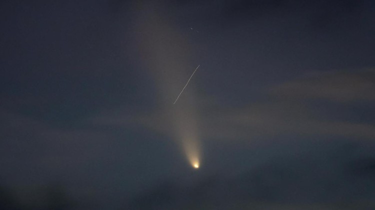 A satellite leaves a trail of light across the tail of the comet C/2023 A3 (Tsuchinshan-ATLAS), with an 80,000 year orbit, known as the comet of the century, after sunset in Ronda, Spain, October 13, 2024. REUTERS/Jon Nazca