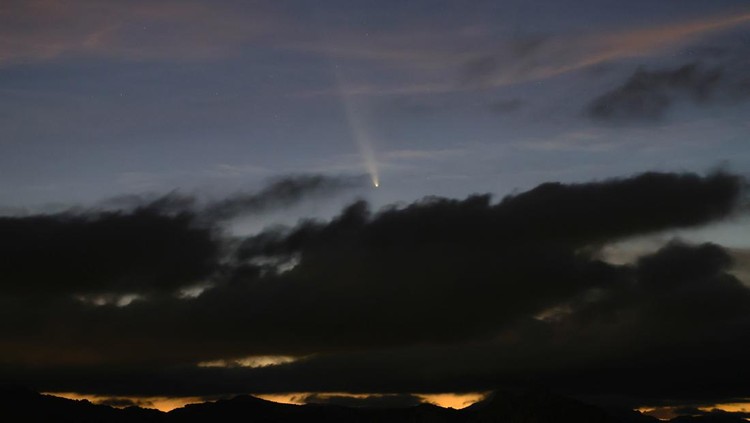 A satellite leaves a trail of light across the tail of the comet C/2023 A3 (Tsuchinshan-ATLAS), with an 80,000 year orbit, known as the comet of the century, after sunset in Ronda, Spain, October 13, 2024. REUTERS/Jon Nazca