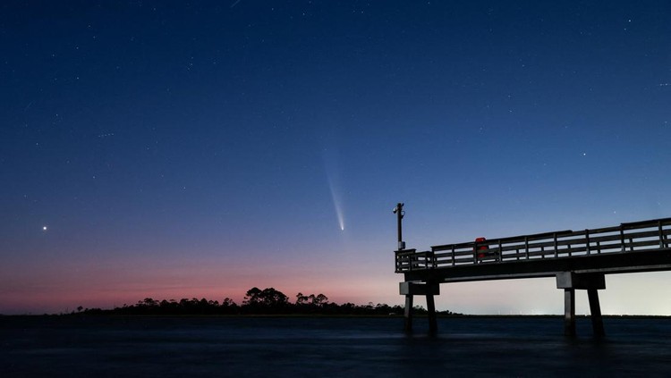 Comet C/2023 A3 (Tsuchinshan-ATLAS) is visible shortly after sunset in the western sky over the Fisherman’s Walk Pier as two men fish, in Tybee Island, Georgia, U.S. October 13, 2024.  REUTERS/Sam Wolfe     TPX IMAGES OF THE DAY