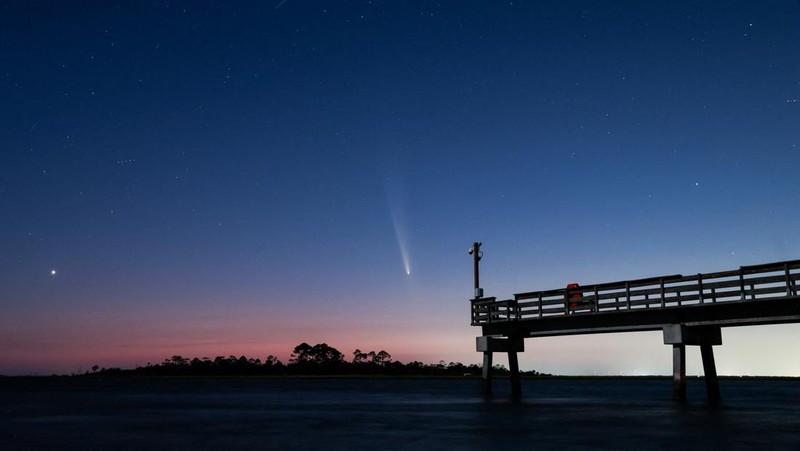 Comet C/2023 A3 (Tsuchinshan-ATLAS) is visible shortly after sunset in the western sky over the Fisherman’s Walk Pier as two men fish, in Tybee Island, Georgia, U.S. October 13, 2024.  REUTERS/Sam Wolfe     TPX IMAGES OF THE DAY