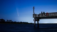 Comet C/2023 A3 (Tsuchinshan-ATLAS) is visible shortly after sunset in the western sky over the Fisherman’s Walk Pier as two men fish, in Tybee Island, Georgia, U.S. October 13, 2024.  REUTERS/Sam Wolfe     TPX IMAGES OF THE DAY