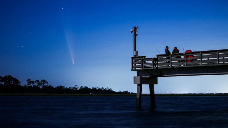 Comet C/2023 A3 (Tsuchinshan-ATLAS) is visible shortly after sunset in the western sky over the Fisherman’s Walk Pier as two men fish, in Tybee Island, Georgia, U.S. October 13, 2024.  REUTERS/Sam Wolfe     TPX IMAGES OF THE DAY
