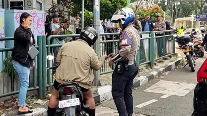 Pengendara motor menyalami polisi usai nyaris menabraknya karena menghindari Operasi Zebra Lodaya di Kota Bogor, Senin (14/10/2024) siang.