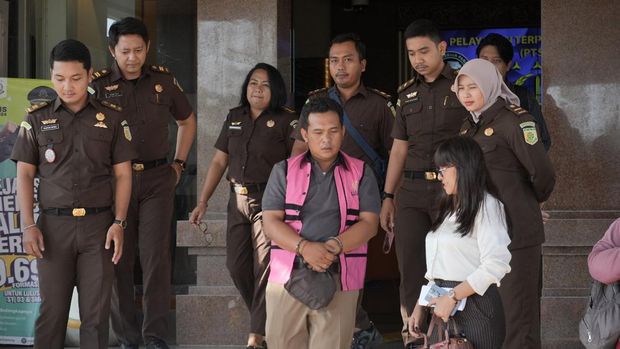 Petugas pencatat meter air berinisial NAD, tersangka kasus pencurian air Perumda Tirta Mangutama di Desa Pecatu, Kecamatan Kuta Selatan, digiring petugas Kejari Badung ke Lapas Kerobokan, Senin (14/10/2024). (Dok. Kejari Badung)
