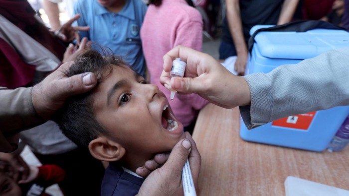 Palestinian child is vaccinated against polio during the second round of a vaccination campaign, amid the Israel-Hamas conflict, in Deir Al-Balah in the central Gaza Strip, October 14, 2024. REUTERS/Ramadan Abed