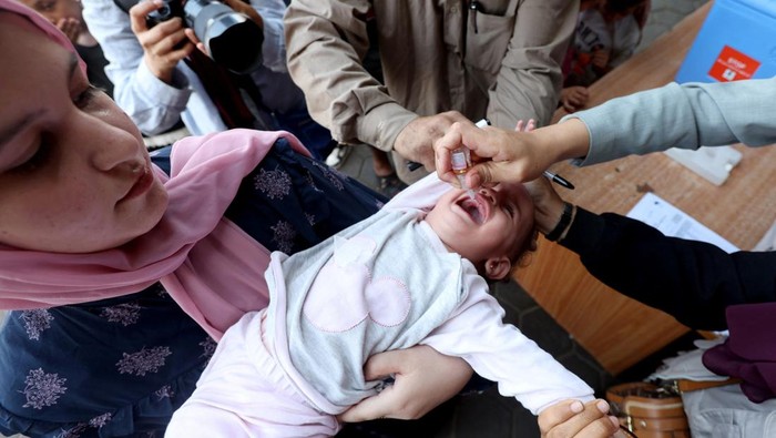 Palestinian child is vaccinated against polio during the second round of a vaccination campaign, amid the Israel-Hamas conflict, in Deir Al-Balah in the central Gaza Strip, October 14, 2024. REUTERS/Ramadan Abed