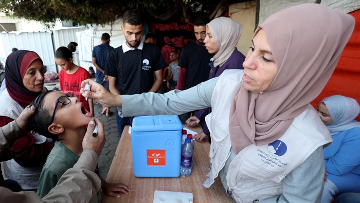 Palestinian child is vaccinated against polio during the second round of a vaccination campaign, amid the Israel-Hamas conflict, in Deir Al-Balah in the central Gaza Strip, October 14, 2024. REUTERS/Ramadan Abed