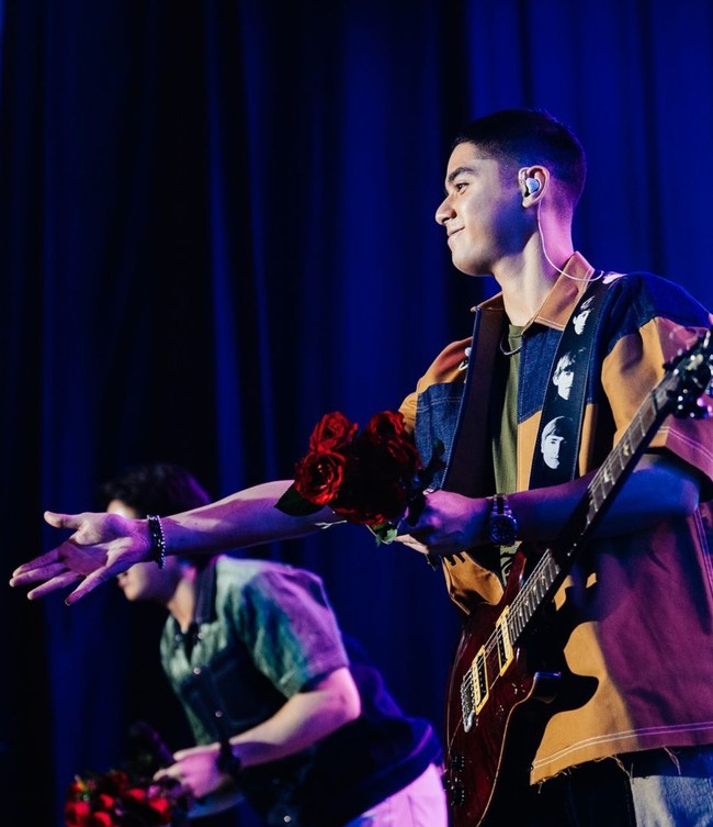 Para personel The Lucky Laki juga sempat melakukan aksi panggung romantis dengan melempar bunga. Dalam foto terlihat Al dan El yang sedang melemparkan bunga mawar merah. Foto: Instagram