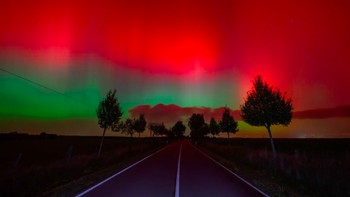 Cahaya utara bersinar di langit malam di atas jalan di Lietzen, Jerman timur. Foto: Patrick Pleul/ AP via Komonews